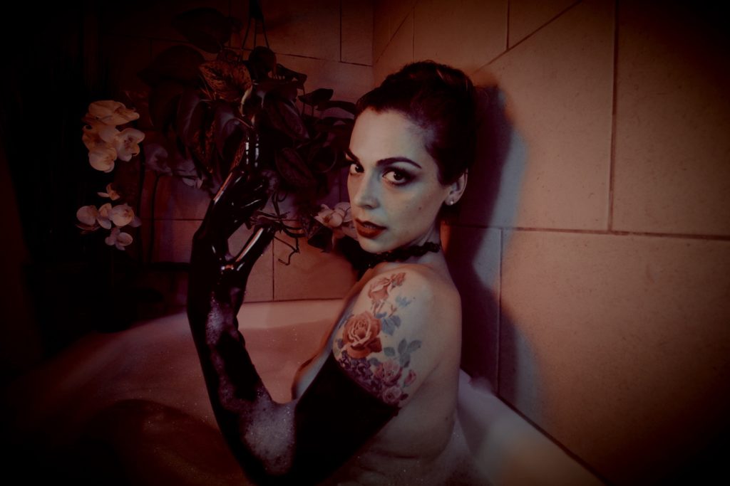 Mistress Pomf wears shiny black latex opera gloves and roleplays as femme fatale in a bubble bath.
