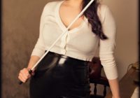 Dominatrix role plays as Teacher in BDSM power exchange.